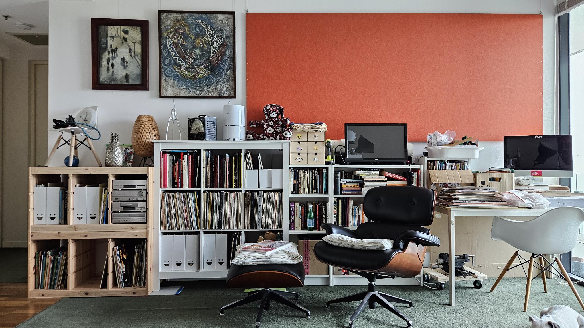 The infoplumbing studio — books, records, an Eames lounge chair, and a terracotta wall in Melbourne.
